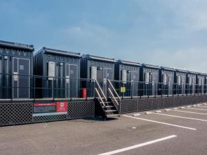 a row of black containers in a parking lot at HOTEL R9 The Yard Isesaki in Isesaki