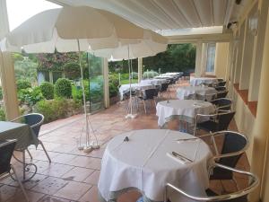 a row of tables and chairs with white tables and umbrellas at Hôtel de Charme Brise Marine in Saint-Jean-Cap-Ferrat