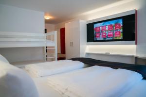 Hotel Andante Rust في روست: غرفة نوم بسريرين وتلفزيون بشاشة مسطحة