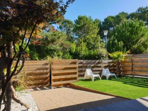 a garden with two chairs and a fence at Blue Ocean in Moliets-et-Maa