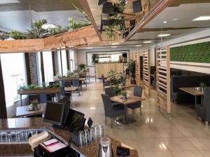 um restaurante com mesas, cadeiras e plantas em Hotel - Restauracja "SŁONECZNA" em Jarocin