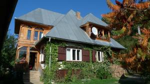 a house with ivy on the side of it at Valea Vinului Suite in Vişeu de Sus