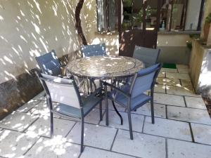 a glass table and chairs on a patio at Le Mas De La Verdiere in Avignon