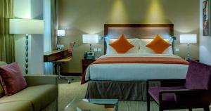 فندق كراون بلازا المدينة في المدينة المنورة: غرفة الفندق بسرير ومكتب واريكة