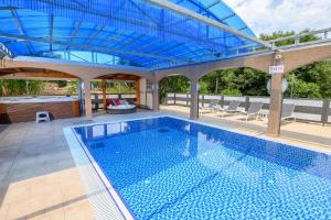 an indoor swimming pool with a blue ceiling at Lev Hahoresh Boutique Hotel in Shomera