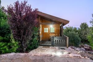 a small cabin with a wooden door in the woods at Lev Hahoresh Boutique Hotel in Shomera