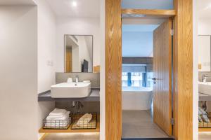 a bathroom with a sink and a tub and a mirror at Hangzhou Yueshang Yunshe Boutique Hostel in Hangzhou