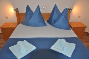 a blue bed with blue pillows on top of it at Apartments Villa Macola in Trogir