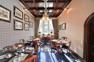 a restaurant with wooden tables and chairs and a window at Boutique Hotel Windsor - The Charming City Hotels in Düsseldorf
