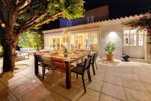 a dining room table and chairs in a backyard at VILLA TIMAUTINE Cannes in Peymeinade