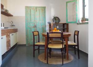 a kitchen with a table and chairs and a door at Studio Aqua in La Oliva