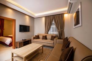 قصر السفير شقق فندقية في الرياض: غرفة معيشة مع أريكة وسرير