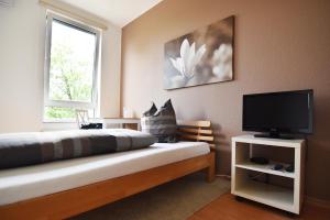 a bedroom with a bed and a flat screen tv at Work and Stay Apartment Cologne- Fühlinger See 