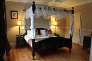 a bedroom with a bed and a canopy at Adare Country House in Adare