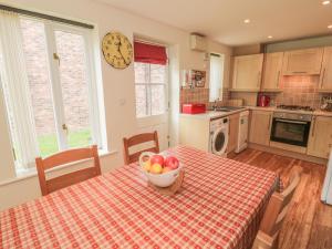 a kitchen with a table with a bowl of fruit on it at White Goose Cottage in Whitby