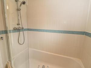 a bathroom with a shower and a bath tub at White Goose Cottage in Whitby +9 photos