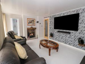 a living room with a couch and a tv on a wall at Ground floor flat in Llandudno