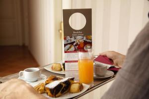 a table with a tray of food and orange juice at Hotel Nuvò in Naples