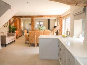 Upper Barn في ستافورد: مطبخ وغرفة معيشة مع طاولة وكراسي