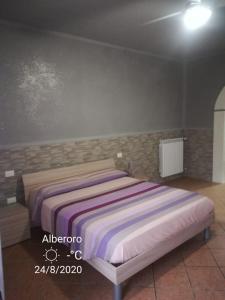 a bedroom with a bed in a room with a wall at Affittacamere New Lifestyle in Alberoro