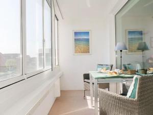 a white room with a table and chairs and a window at Seedeich Apartment in Cuxhaven
