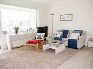 ein Wohnzimmer mit einem Sofa und einem Tisch in der Unterkunft Seedeich Apartment in Cuxhaven