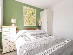 a bedroom with a bed and a painting on the wall at Swanage Town Apartment in Swanage
