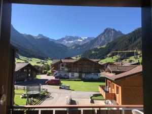 uma vista a partir de uma janela de uma cidade com montanhas em Chalet Mittaghorn em Adelboden