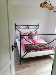 een slaapkamer met een zwart-wit bed met roze kussens bij Fahrenbach-Alm in Tröstau