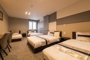 En eller flere senge i et værelse på GRAND BASE Nagasaki Chukagai