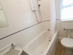 Un baño blanco con inodoro y lavabo. en Rospletha Bungalow, en Penzance