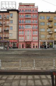 Central Plaza Hotel في صوفيا: مبنى احمر امام بعض المباني