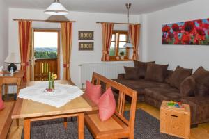 a living room with a couch and a table at Stadlerhof in Frasdorf