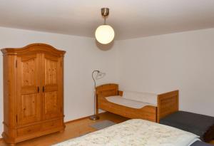 a bedroom with a bed and a wooden cabinet at Stadlerhof in Frasdorf