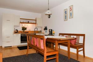 cocina con mesa de madera y sillas en una habitación en Stadlerhof, en Frasdorf