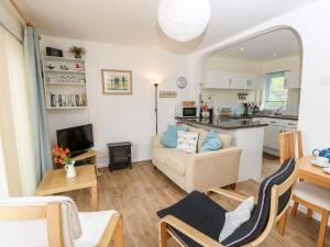 a living room with a couch and a table at Buddleia Cottage in Seaview