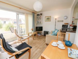 a living room with a table and chairs and a couch at Buddleia Cottage in Seaview