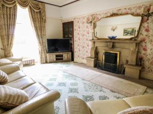 a living room with a couch and a fireplace at Manor House in Accrington