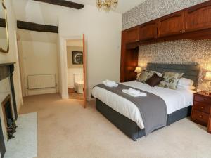 a bedroom with a large bed and a fireplace at Manor House in Accrington