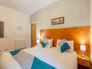 - une chambre avec un grand lit et une tête de lit en bois dans l'établissement OYO Eastbank Hotel, Speyside Scotland, à Rothes