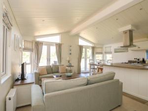 a living room with two couches and a kitchen at Pentney Lodge in Kings Lynn