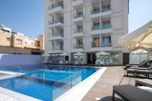 a swimming pool in front of a building at Best Western Plus Larco Hotel in Larnaka