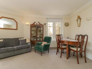 a living room with a couch and a table and chairs at 1 Abbey Court in Sherborne