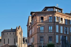 an old brick building next to a church at Chambre d'Elvire in Albi