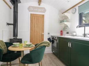 a kitchen with a table and chairs and a stove at High Rigg Shepherd's Hideaway in Brampton