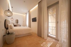 a bedroom with a bed and a large window at Albariza Hotel Boutique in Sanlúcar de Barrameda