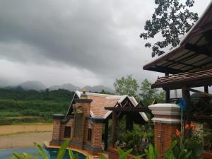 un piccolo edificio con una statua di fronte a una casa di Chateau Orientale Resort a Luang Prabang