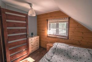 una camera da letto con un letto e una finestra di WANATÓWKA a Korczyna