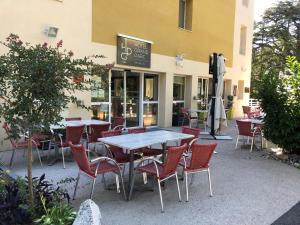 een tafel en stoelen buiten een restaurant bij Hotel du Grand Parc in Gex