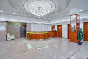 een grote lobby met een kroonluchter in een gebouw bij Markstadt Hotel in Tsjeljabinsk